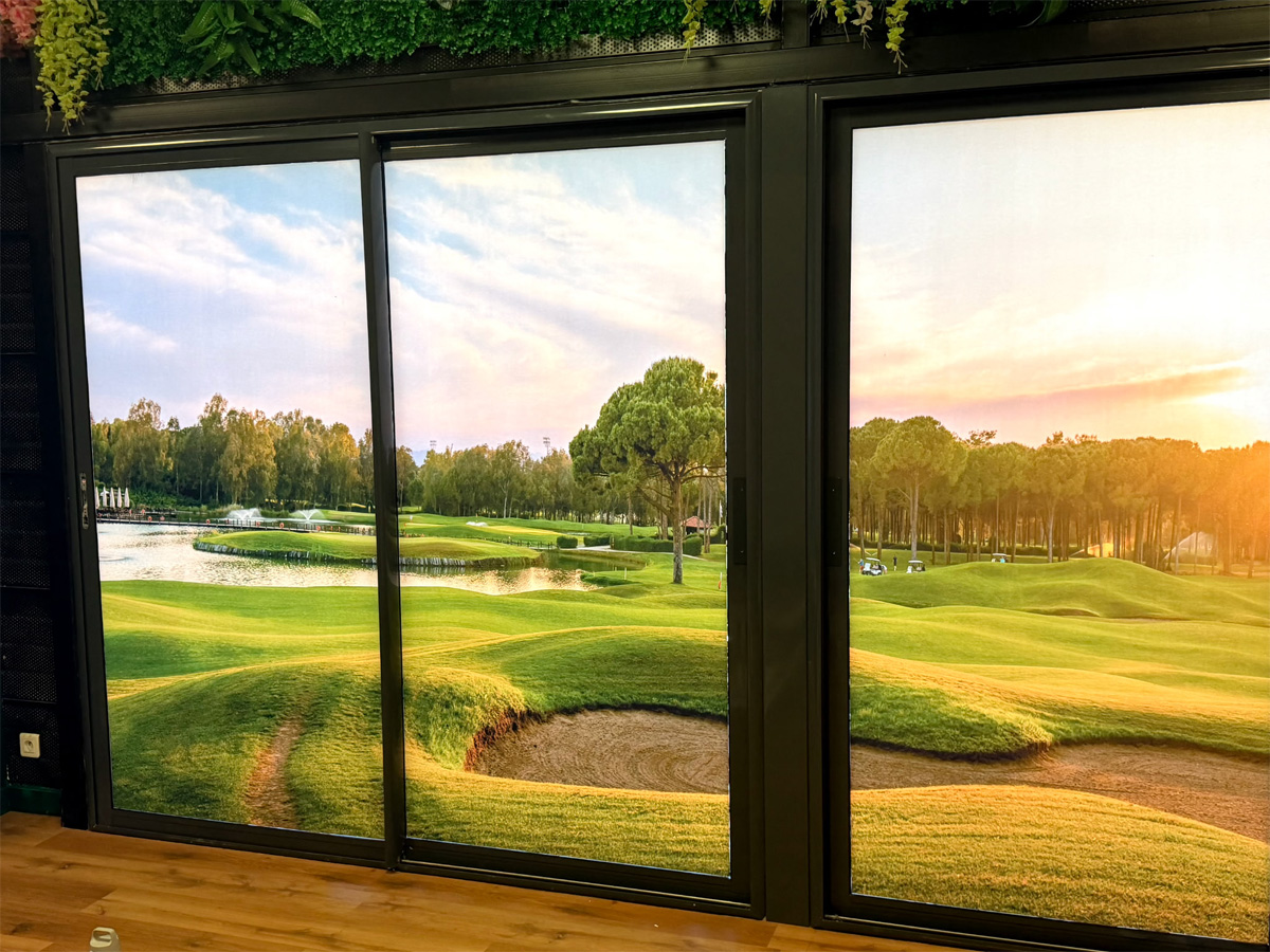Décor immersif du golf indoor de Saint-Lô avec visuel de parcours de golf sur les vitres intérieures